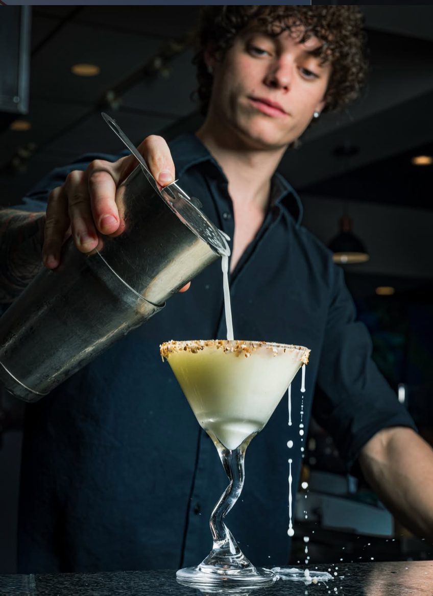 Bartender shaking and pouring a craft margarita